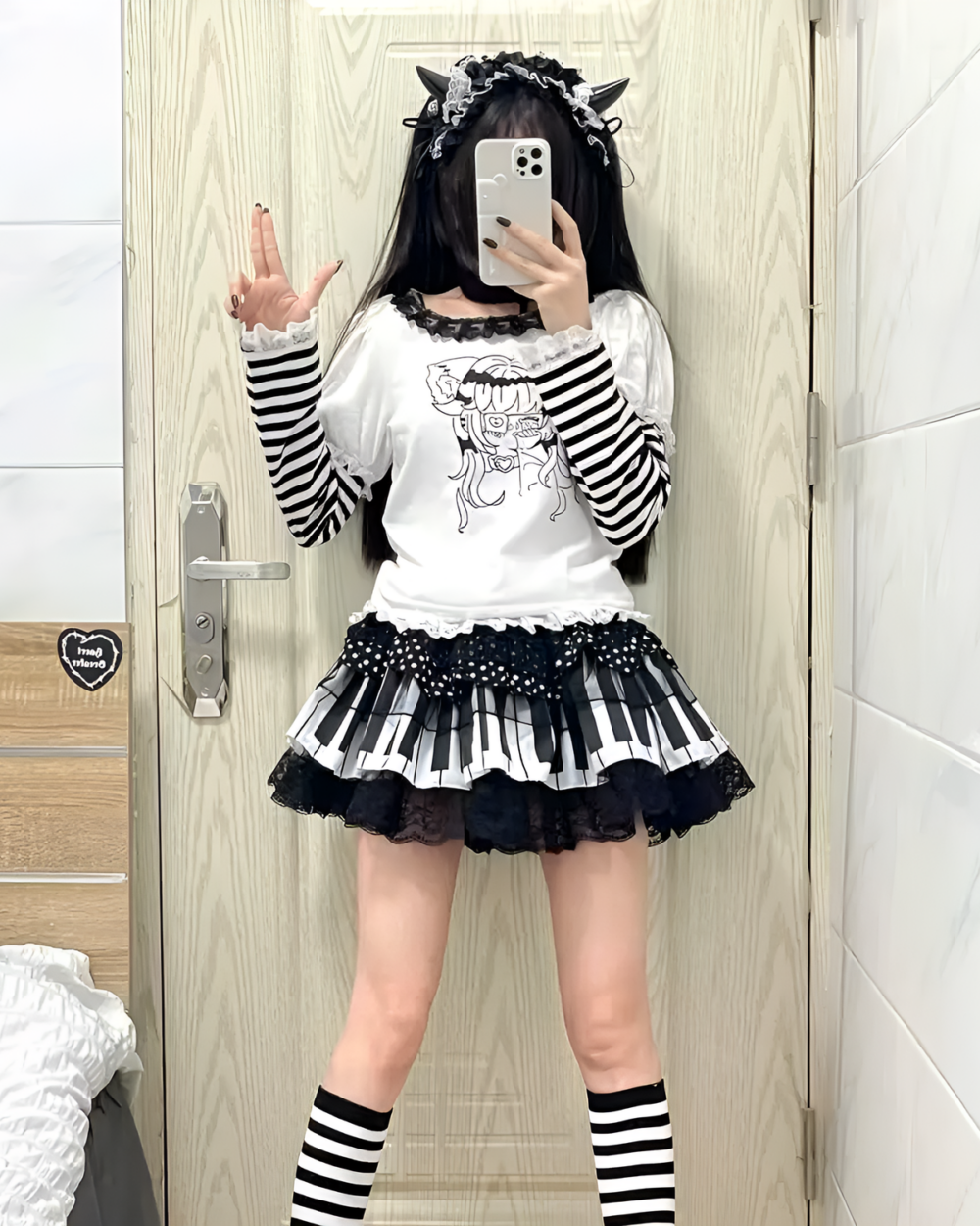 Woman modeling a Noir Sonata Skirt, a black and white piano key skirt, with striped socks and a white top.