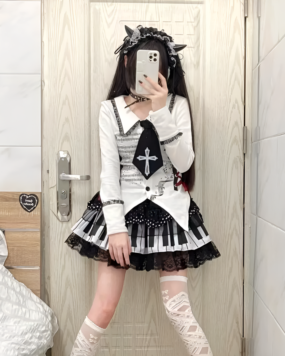 Model wearing the Noir Sonata Skirt, a black and white piano key skirt, with a lace top and headband.