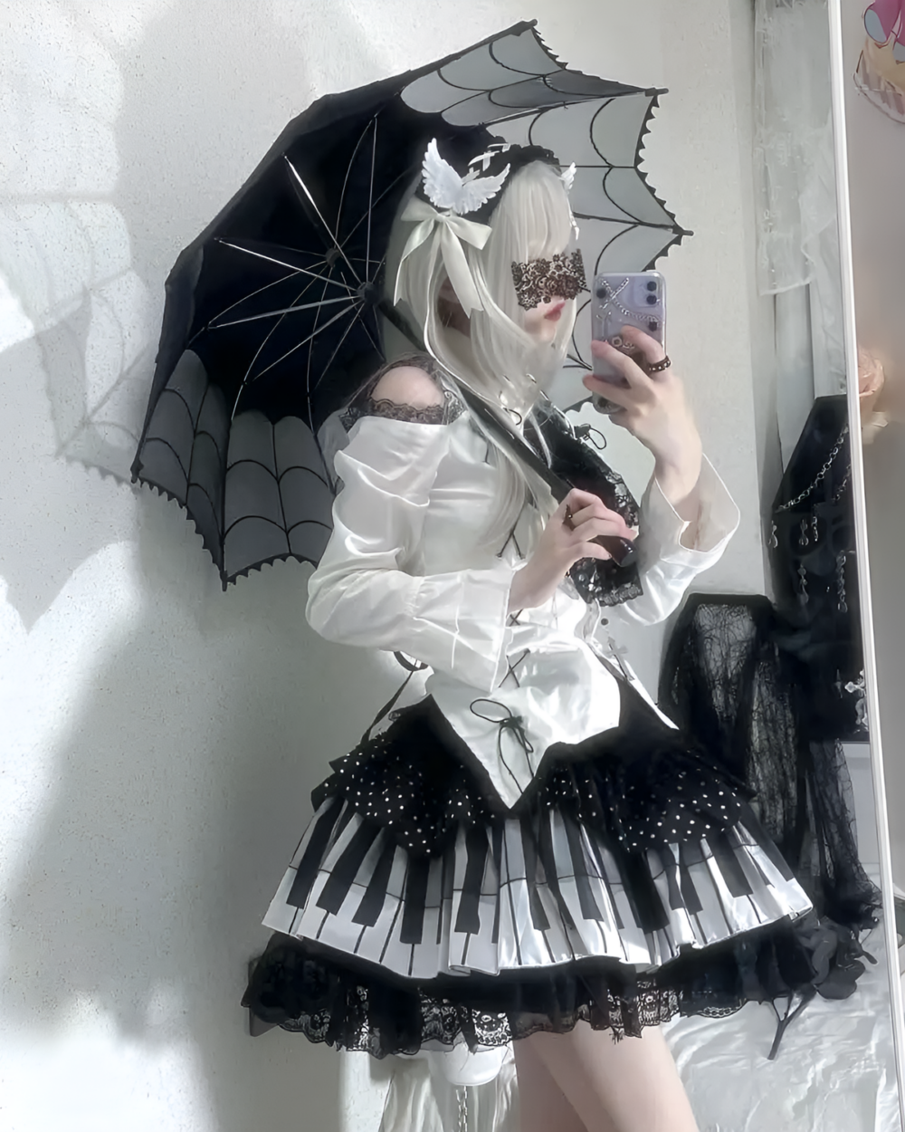Woman modeling the Noir Sonata Skirt, a black and white piano key skirt with a ruffled hem, paired with a white blouse and lace accents.