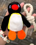 Close-up of a Noosed Penguin Keychain, a plush penguin toy attached to a rope key chain.