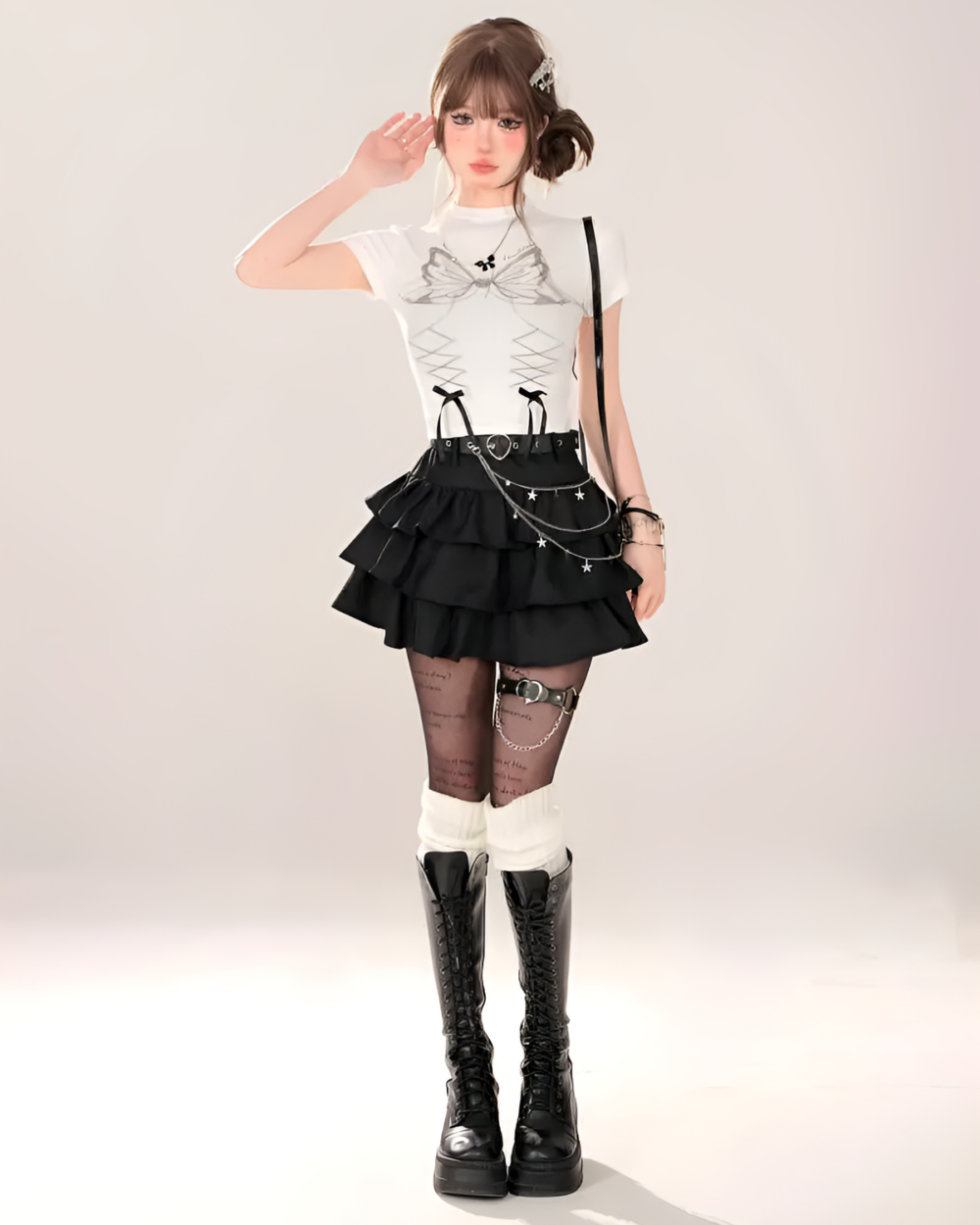 Model wearing a black Obsidian Star-Chain Mini Skirt with a white top and black boots. The skirt features a layered design and star details, part of the star chain skirt collection.
