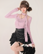 Model wearing a pink top and black star chain skirt with tiered ruffles and a black belt. The skirt features a star pattern.