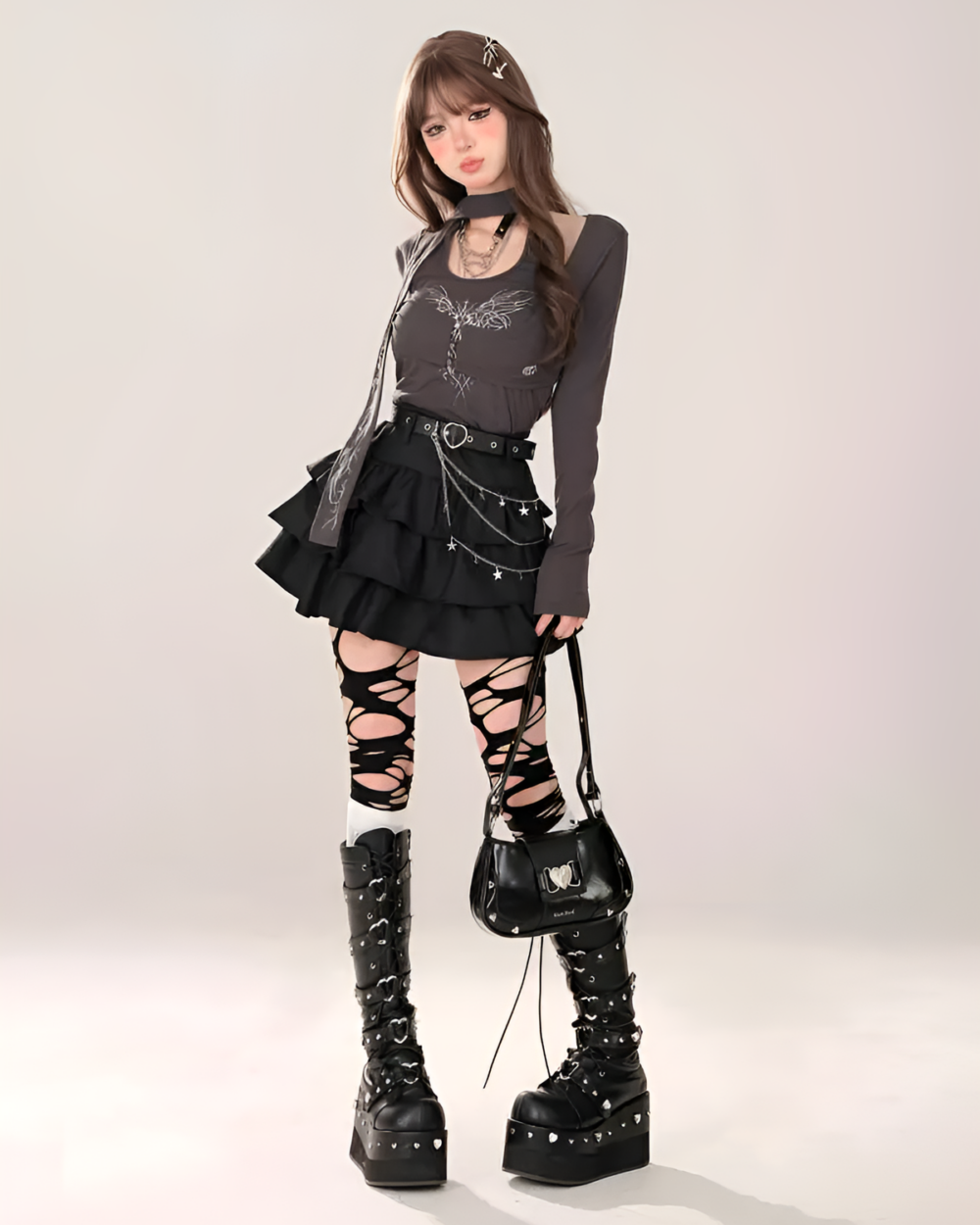 Model wearing a black star chain skirt with a dark grey long sleeve and platform boots. The star chain skirt features a layered, cutout design.