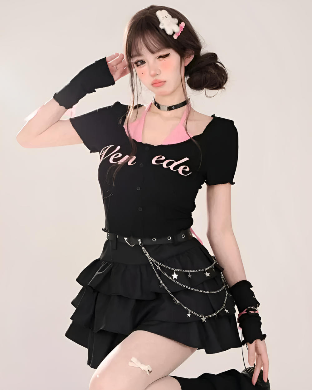 Model wearing a black top and a black star chain skirt with tiered ruffles and star details. The skirt features silver chain accents.