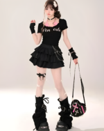 Model wearing a black star chain skirt with a black graphic tee and platform boots. The skirt has multiple layers and chain details.