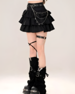 Black mini skirt with star chain details. This star chain skirt features a layered ruffle design and leg chain accents.