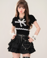 Model wearing a black top and Obsidian Star-Chain Mini Skirt with star details and layered ruffles. Featuring a star chain skirt design.