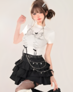 Model wearing a white t-shirt and black star chain skirt with star details and a tiered design. This is a star chain skirt.