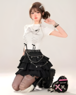 Model wearing a black star chain skirt with a white top and boots. The star chain skirt has a layered, ruffled design.