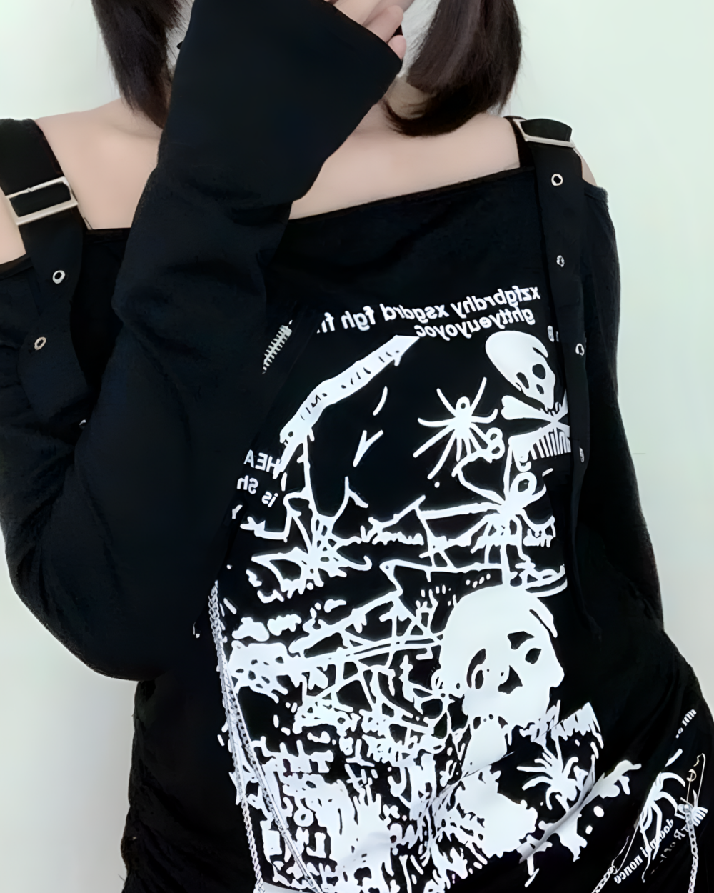 Black Nu-Goth sweater with off-shoulder detailing and graphic print.