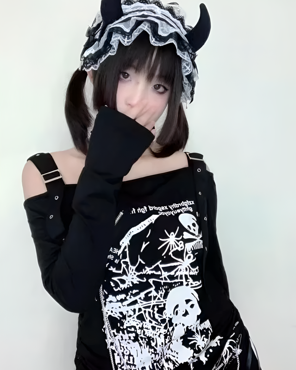Black Nu-Goth sweater featuring skull graphics and lace details. Off-shoulder design.