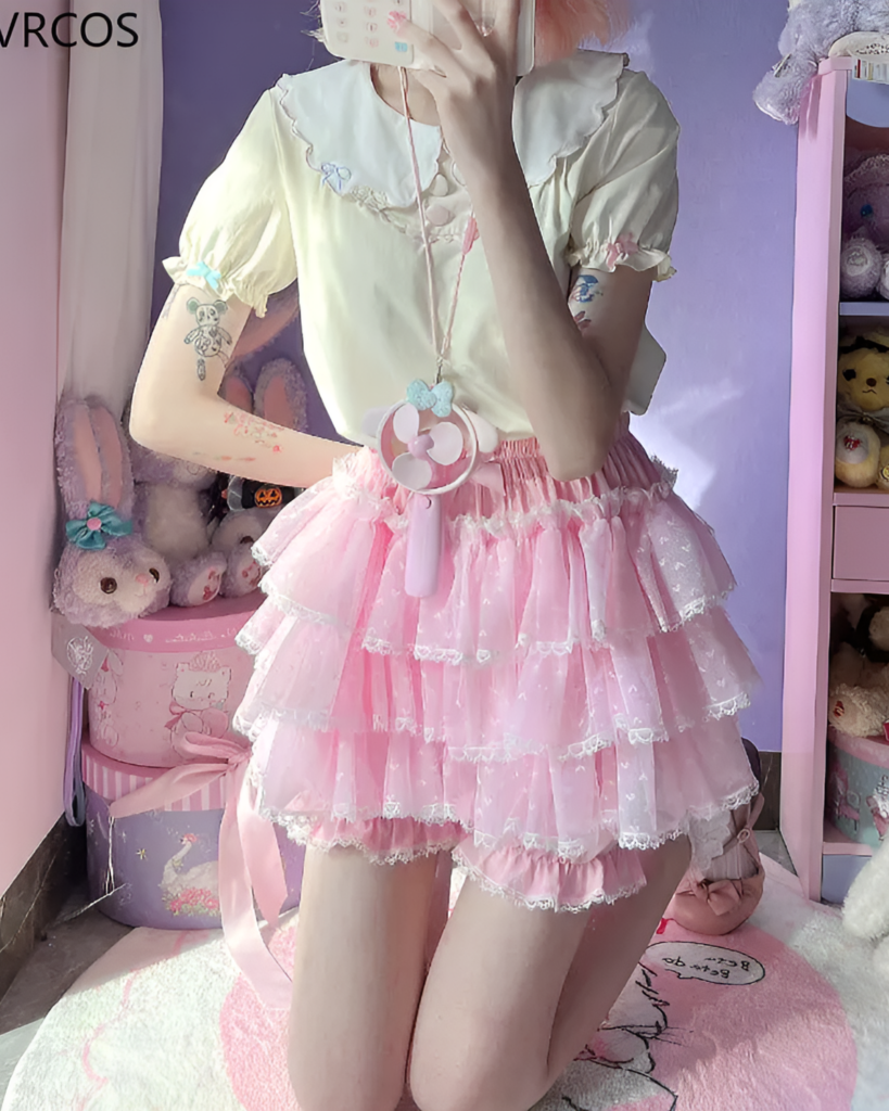 Model wearing Pastel Heart Frill Bloomers with a white ruffled top and pink accessories, showcasing a Yume Kawaii aesthetic.