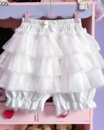 White Pastel Heart Frill Bloomers hanging on a pink clothes rack. These Yume Kawaii aesthetic bloomers feature ruffled layers.