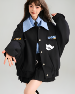 Woman wearing a black Patchy Jacket with colorful patches. Preppy aesthetic outerwear.