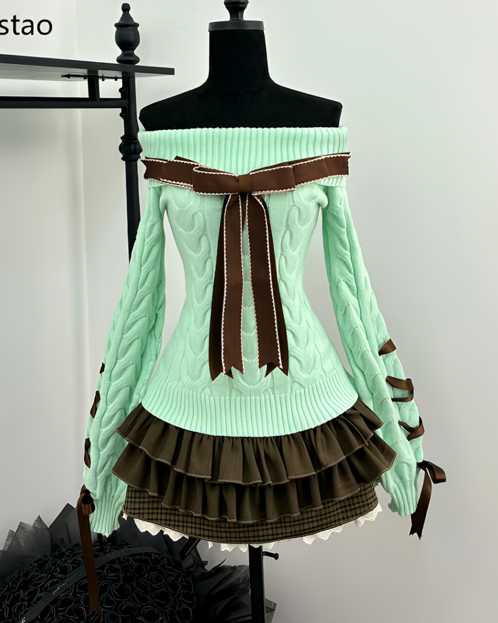 Mint knit set featuring a pale green sweater with ruffle skirt and bow details, displayed on a mannequin.