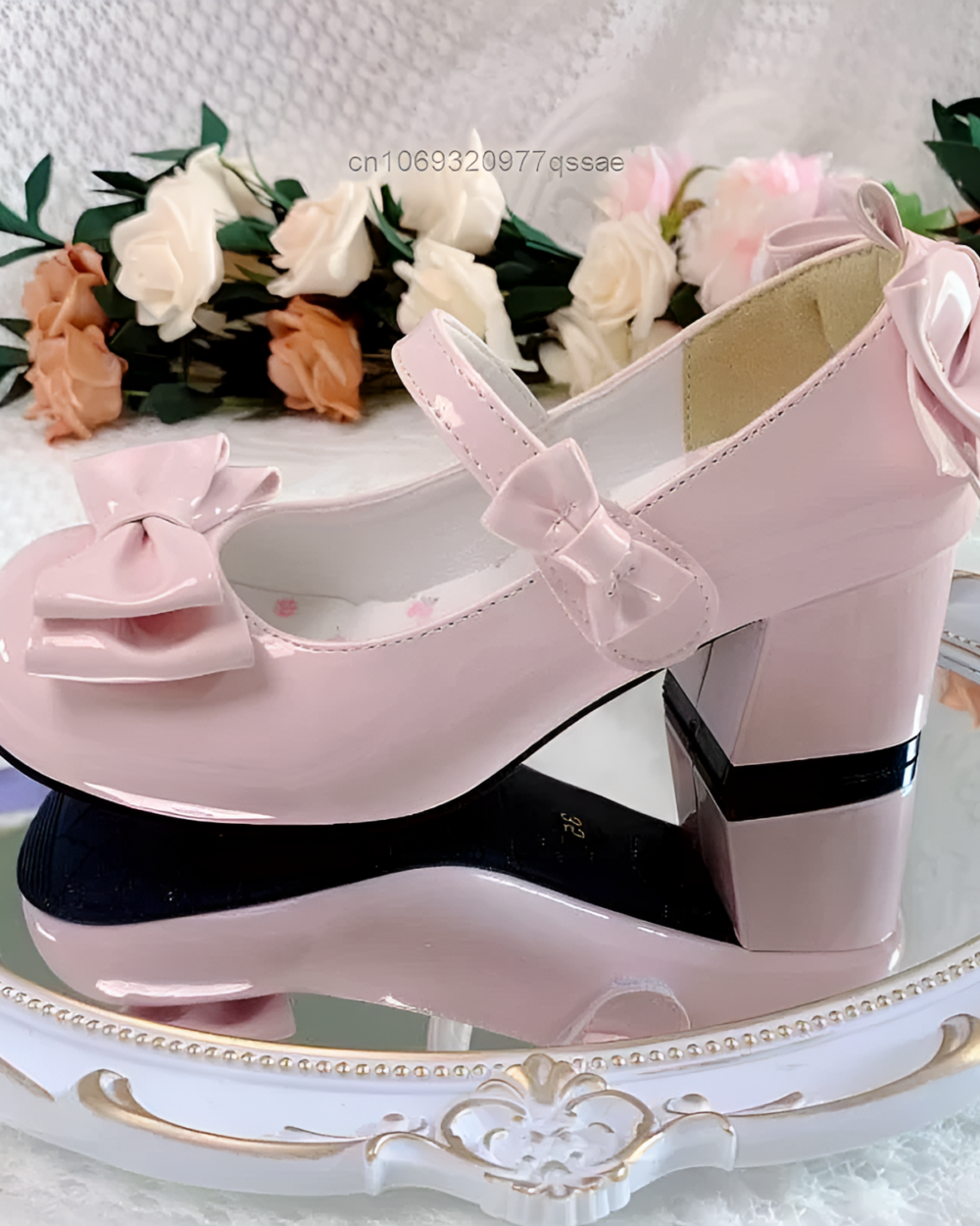 Pink Petal Block-Heel Mary Janes with a bow detail, shown on a decorative surface. Features a block heel and rounded toe.