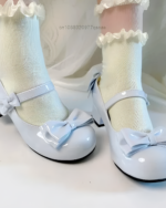 Light blue Petal Block-Heel Mary Janes with bow details and low block heels, styled with white socks.