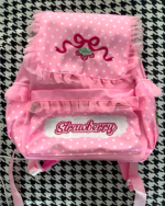 Pink strawberry backpack featuring ruffles and embroidery, Jojifuku Aesthetic.