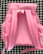 Pink strawberry backpack featuring a polka dot design and ruffle details.