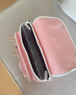 Open pink strawberry ita bag with interior lining and strap.