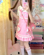 Woman wearing a pink strawberry mini dress by Jojifuku. The dress features a ruffled hem and strawberry details.