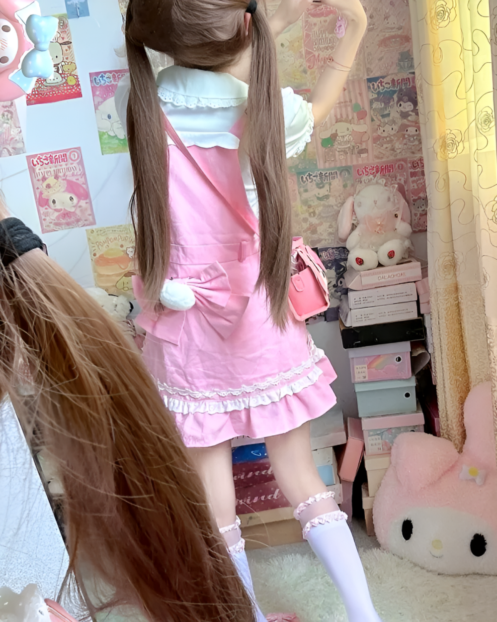 Model wearing a pink strawberry mini dress by Jojifuku. Aesthetically pleasing, with ruffles and lace details.