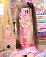 Person wearing a pink strawberry mini dress by Jojifuku. Features strawberry prints on the dress and phone case.
