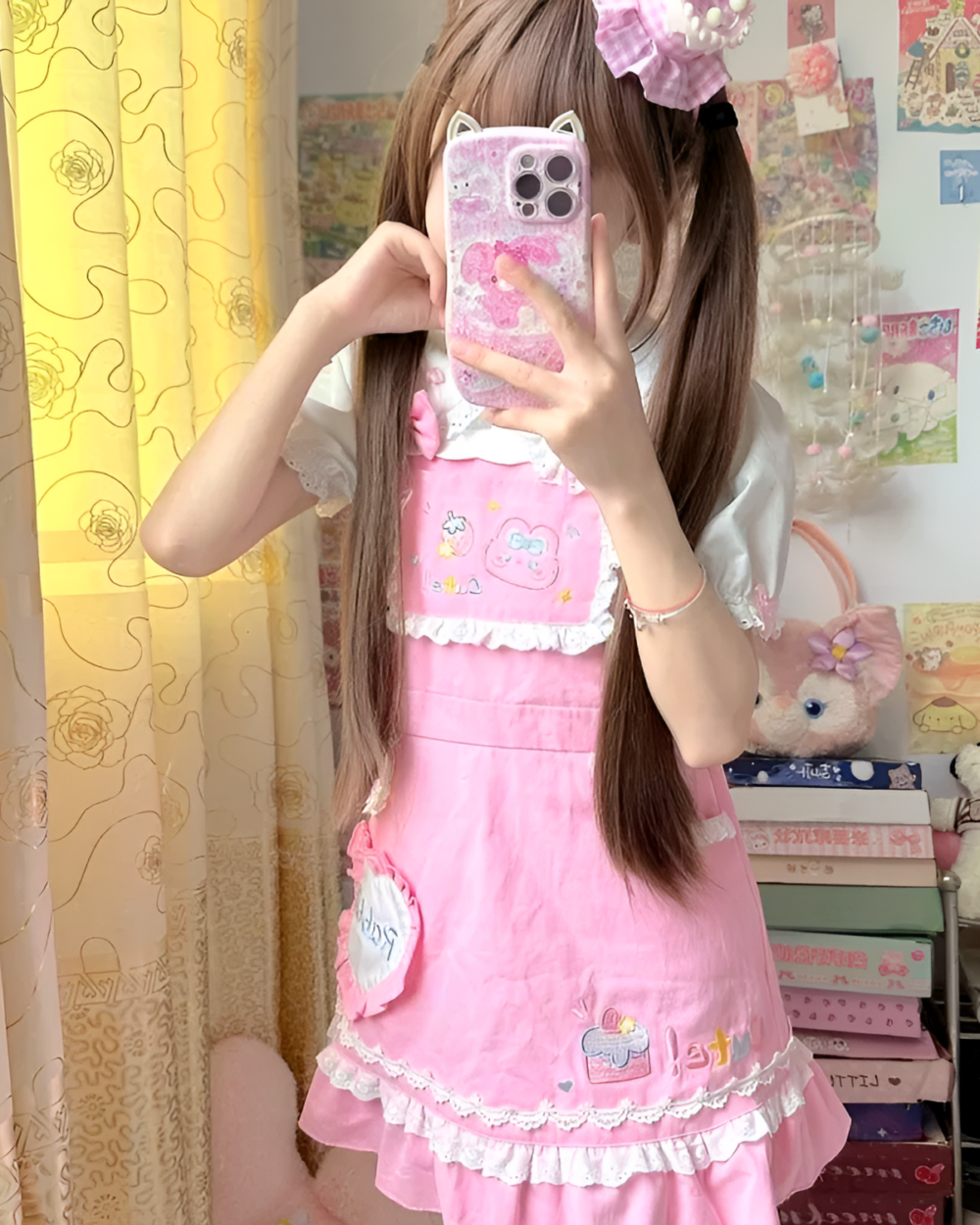 Woman modeling a pink strawberry mini dress by Jojifuku Aesthetic. The dress has strawberry details and a ruffled hem.