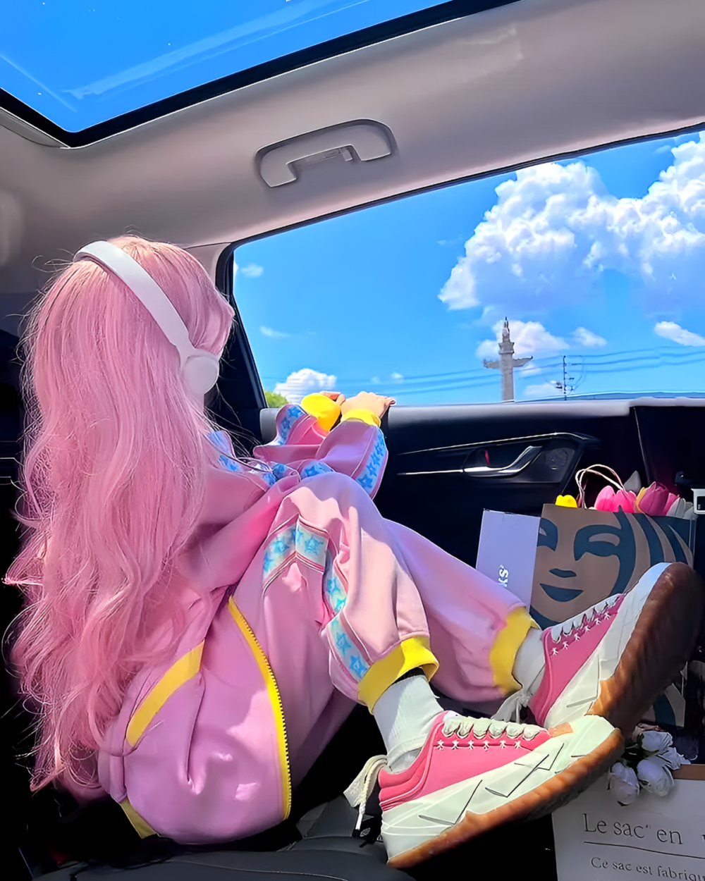 Pink and Yellow Tracksuit - Yume Kawaii tracksuit, person sitting in a car, sunny day.
