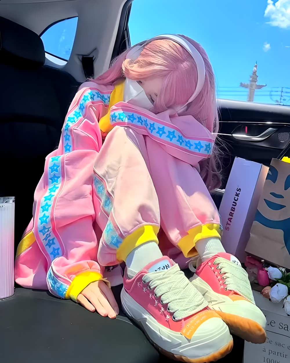 Pink and Yellow Tracksuit - Yume Kawaii tracksuit featuring a woman with layered hair and star details, sitting in a car.