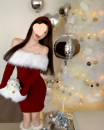 Woman wearing a red Plush Christmas Dress with faux fur trim, near a Christmas tree and balloons.