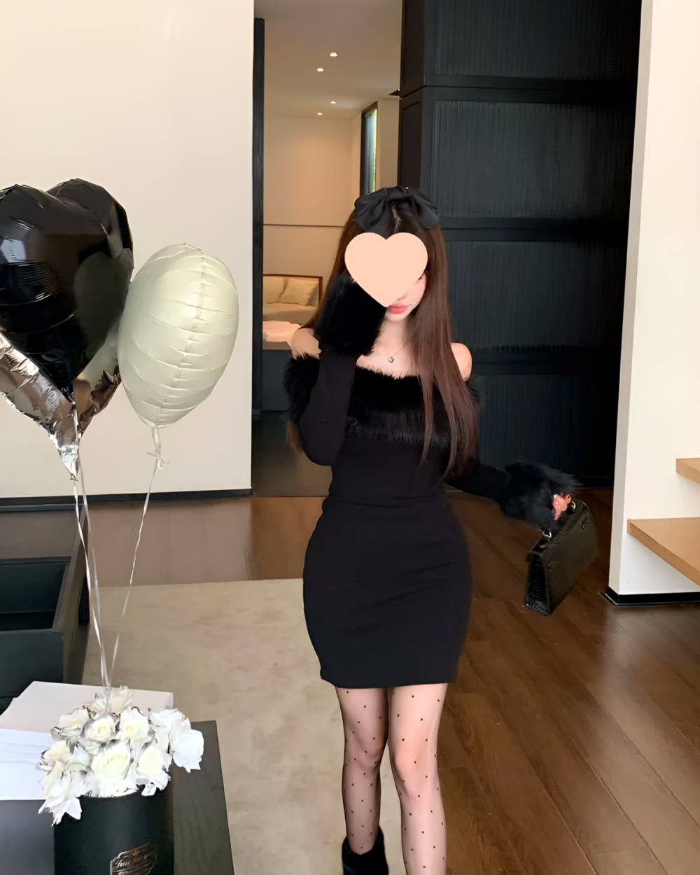 Woman wearing a black Plush Christmas Dress with long sleeves, near balloons and a gift box.