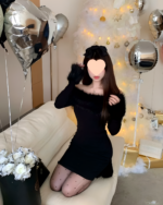 Woman wearing a black Plush Christmas Dress with a faux fur shawl, surrounded by Christmas decorations.