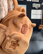 Close-up of a brown Capybara plushie bag with a zipper and embroidered details.