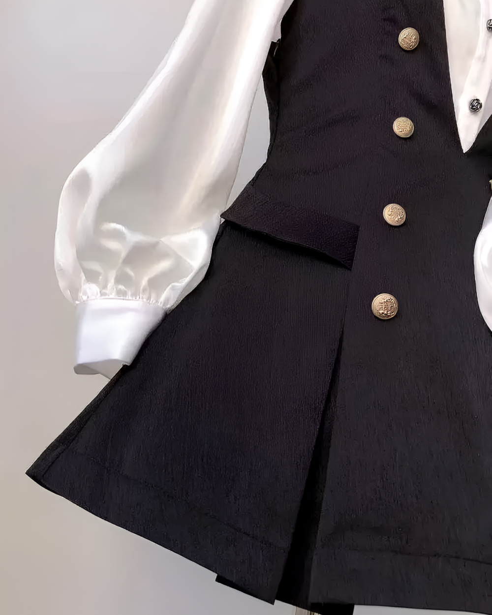 Close-up of a black Ouji aesthetic dress set featuring a vest and blouse with puffed sleeves.