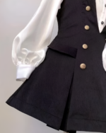 Close-up of a black Ouji aesthetic dress set featuring a vest and blouse with puffed sleeves.
