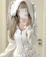 White rabbit eared hoodie with floral print and rabbit ears on the hood. A person takes a selfie wearing the hoodie.