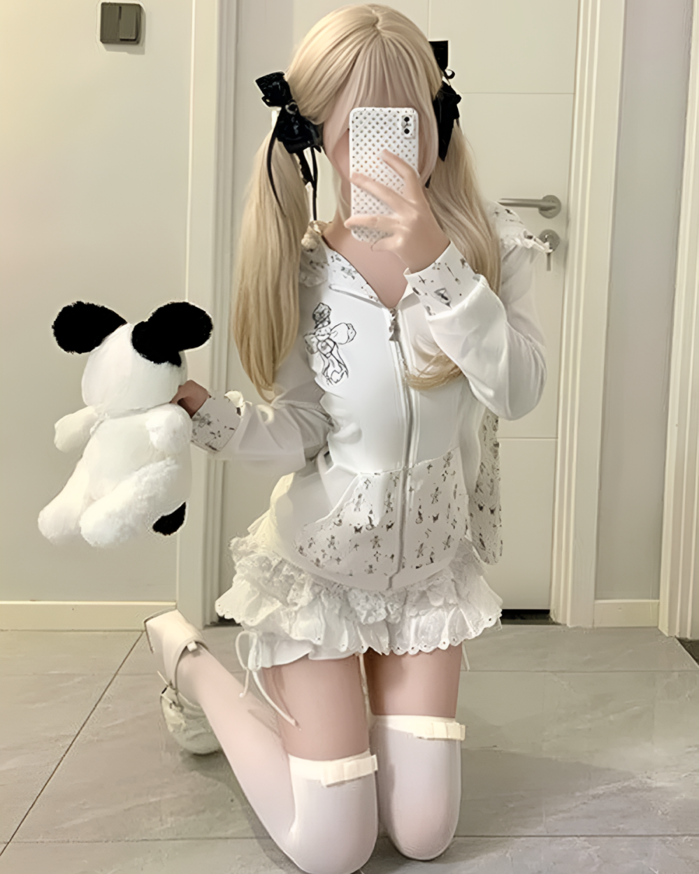 Woman wearing a white floral rabbit eared hoodie and knee-high socks, posing with a stuffed animal.