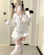 Woman wearing a white rabbit eared hoodie with floral details and thigh-high socks, taking a selfie.