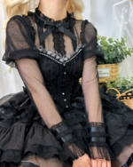 Close-up of a black Hime Lolita blouse with sheer sleeves, lace details, and a bow.