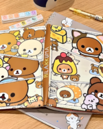 Rilakkuma notebook with Rilakkuma characters, pencil, and desk accessories.