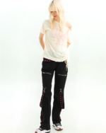 Woman wearing black Riot Star-Strap cargo pants, a Y2K aesthetic style with star details and lace-up sides.