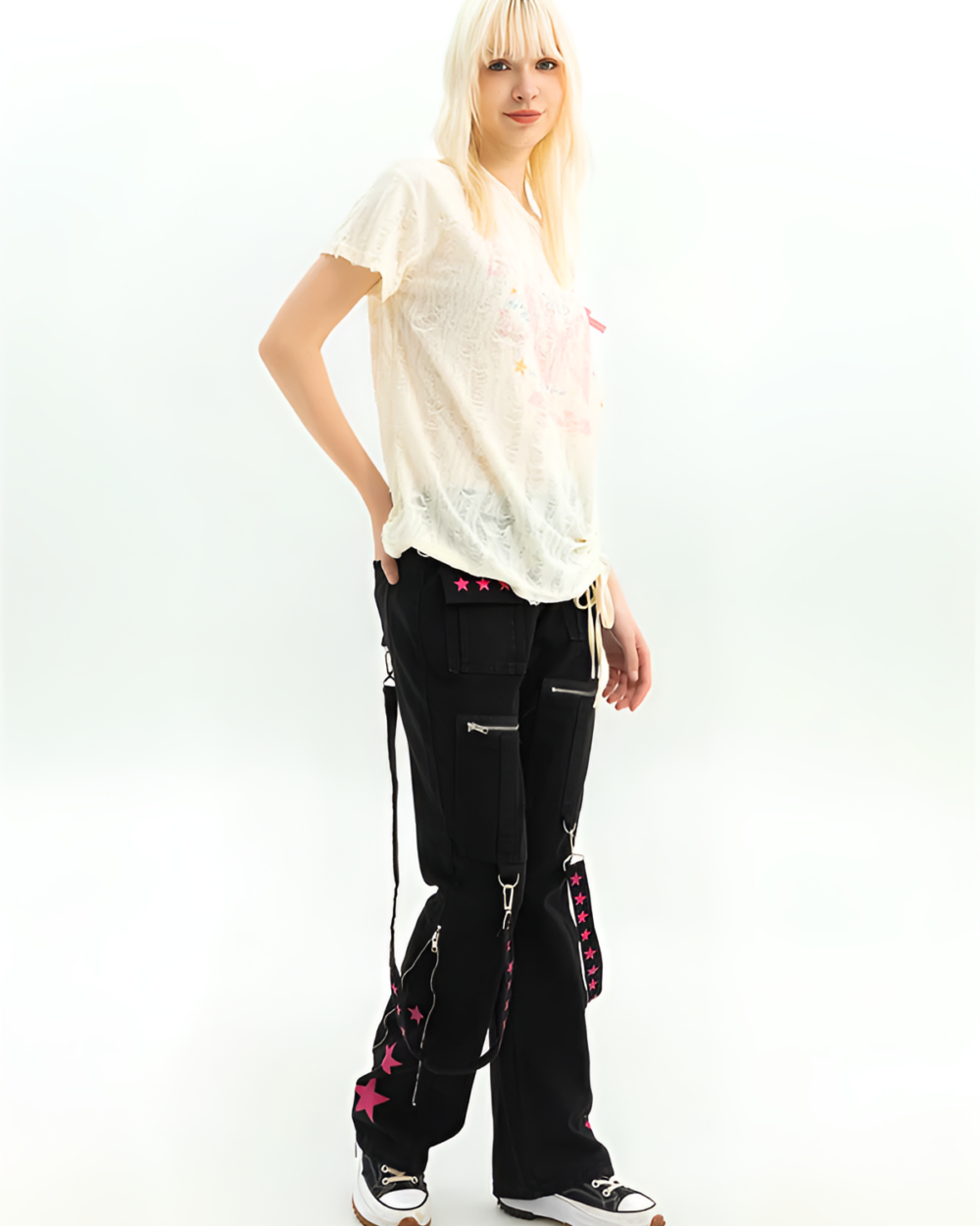 Woman wearing black Riot Star-Strap Cargo Pants, a style of Y2K cargo pants with star details and adjustable straps.