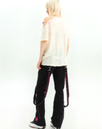 Woman wearing black Y2K cargo pants with pink star details, back view.