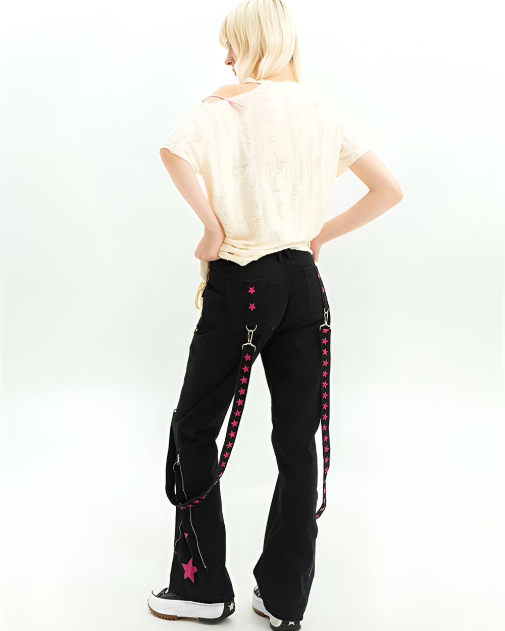 Black Y2K cargo pants with pink star details, worn with a white top. Back view showcasing the strap design.