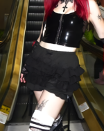 Woman wearing ruffled dark bloomers and a black top, showcasing a mall goth aesthetic. Black skirt and platform shoes visible.