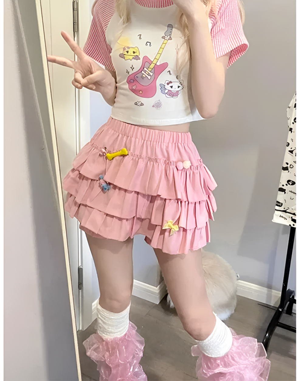 Pink ruffled mini skirt paired with a graphic sweatshirt and socks.