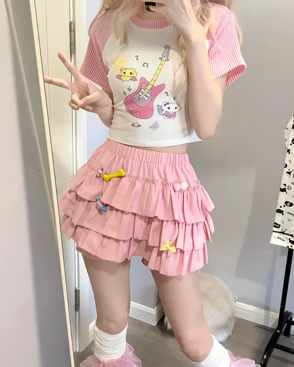 Pink ruffled mini skirt worn with a graphic tee and socks.