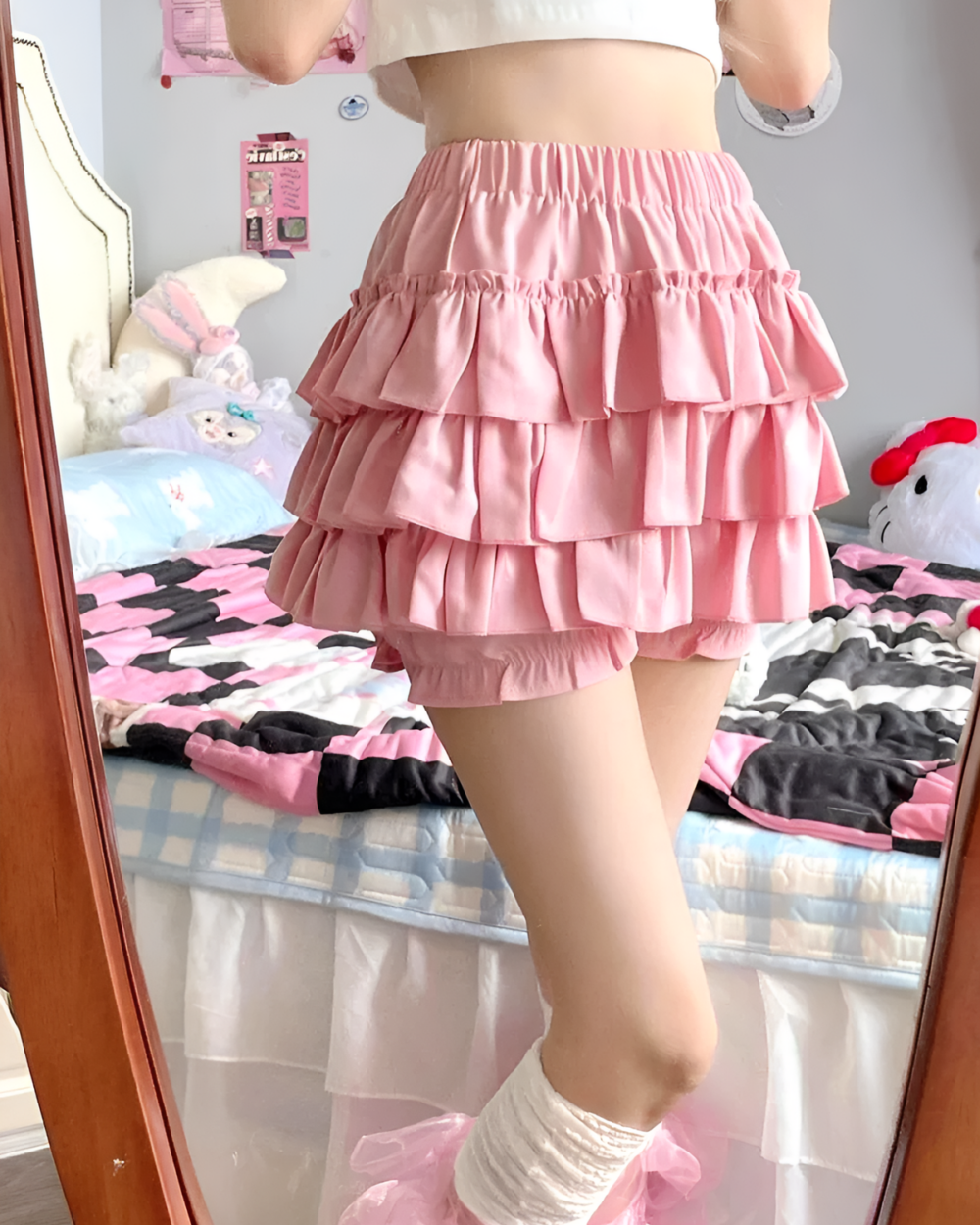 Pink ruffled mini skirt worn by a person, layered ruffles and a casual style.