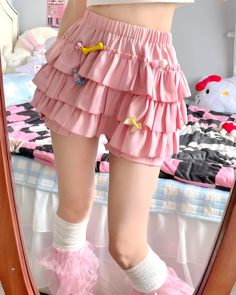 Pink ruffled mini skirt with layered ruffles and decorative charms.